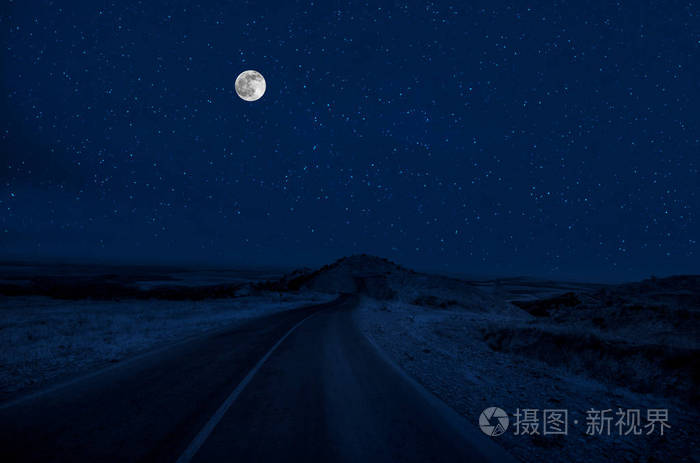 满月之夜,山路穿过森林. 夜晚风景优美的乡村道路,有大月亮