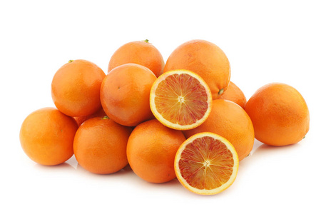 一堆新鲜的血橙和一个白色背景的切制橙子