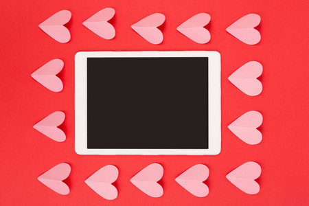 平板触摸板与空白屏幕在红色背景与剪纸心脏
