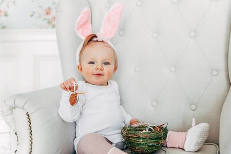 复活节穿兔子耳朵的小女孩。 女孩拿着篮子，在家里装饰彩蛋，玩复活节彩蛋狩猎。 节日庆典春节概念