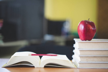 s desk with stack of books and apple, Educational concept.