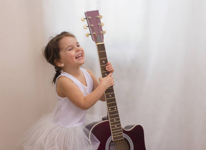 一个穿着雪花服装，带着吉他的小笑女孩