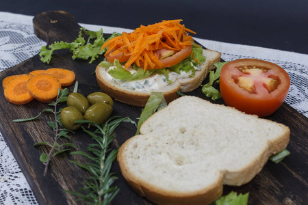 健康的素食三明治，胡萝卜番茄生菜和香料放在木板上。