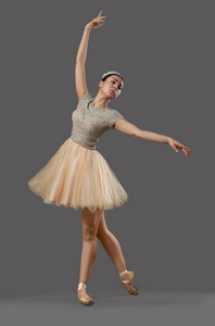 芭蕾在米色礼服和芭蕾鞋跳舞在演播室
