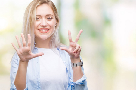 年轻的金发女子在孤立的背景显示和指着8号手指，同时微笑自信和快乐。