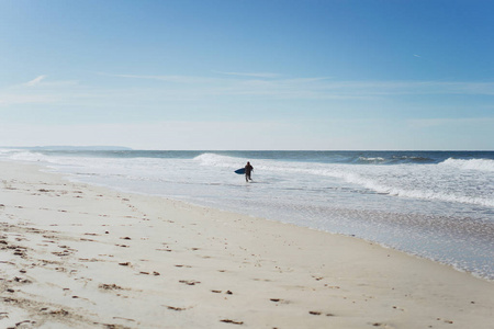 在海边有冲浪板的人。穿着湿衣服冲浪。拿撒勒，葡萄牙。