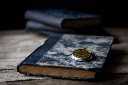 木制桌子上的旧书和怀表。
