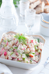 沙拉与蟹棒和米饭在一个小沙拉碗在白色的桌子上选择性的焦点图片