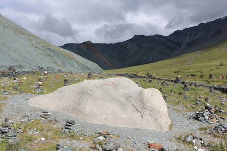 巨石与象征和平的旗帜在雅鲁峡谷的彩色山脉阿尔泰俄罗斯的背景