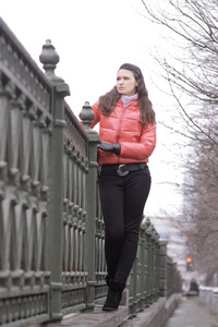 年轻女人站在城市的桥上