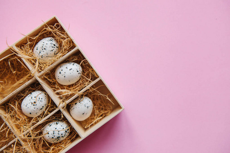 在粉红色背景上的盒子或容器中的一组鸡蛋。节日复活节概念在最小的风格