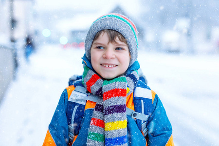快乐的孩子男孩玩雪在去学校的路上