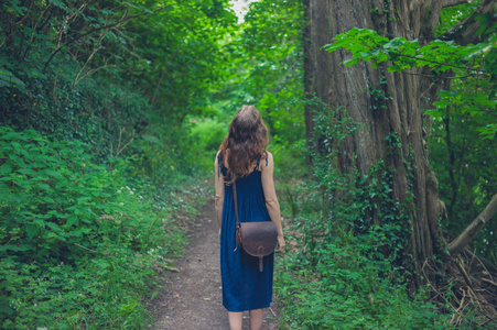一个年轻的女人正在森林里散步