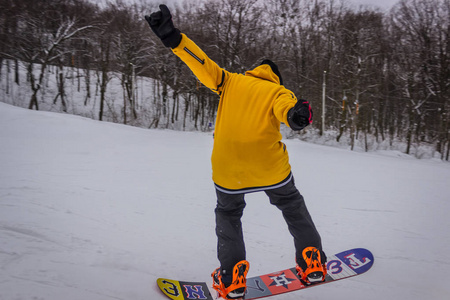 男性滑雪板弯曲和刹车喷洒松散的深雪在自由坡。