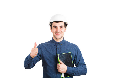 开朗的年轻人工程师戴着防护头盔，手持平板电脑，拇指向上，积极反馈，手势看着相机，微笑着孤立在白色背景上。