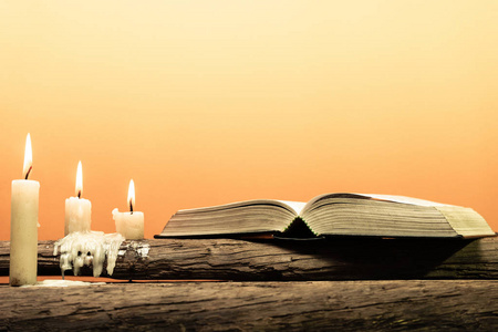 古老橡木木桌上的圣经。 漂亮的橙色背景。 宗教观念。