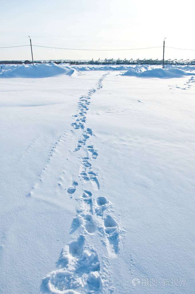 暴风雪过后,一个建筑工地霜冻的日子里,雪中的脚印.
