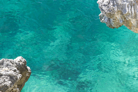 清澈的绿松石海水，看着底部，悬在岩石的角落