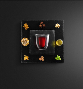 覆盖葡萄酒配方成分和厨房配件瓶红酒肉桂八角星橙色红糖和香料黑色背景。