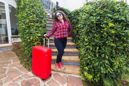 假日, 旅行, 人概念戴着太阳镜的年轻女子站在楼梯上, 带着行李箱和微笑