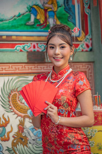 穿着红色连衣裙的亚洲女孩站在中国新年的圣地。