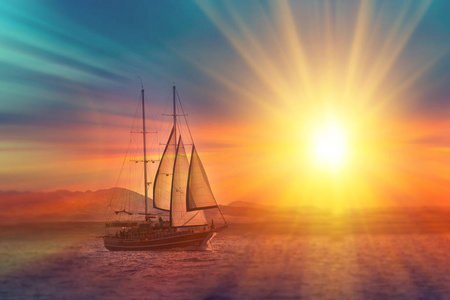 日落时在宁静的海洋上的古老的海盗船。 平静的波浪反射日落。