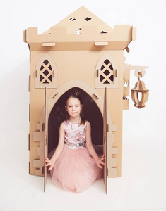 小公主在皇冠上玩她的纸板城堡。孩子幸福的真实情感
