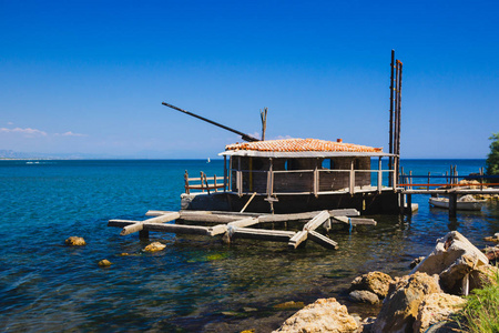 渔民在黑山亚得里亚海海岸边建造。 原装钓鱼器械阳光明媚的夏日蓝天和水。