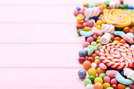 粉色木桌上的糖果和棒棒糖