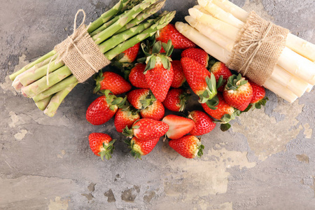 白色和绿色的新鲜芦笋和一串健康的草莓