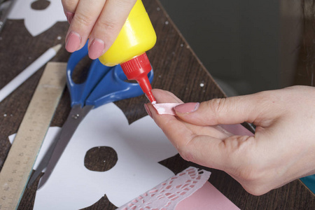 用纸板和胶带制作贺卡。 用胶水工作的女工匠。