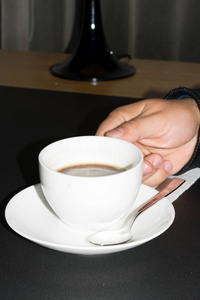 咖啡时间。 男人的手在早上的咖啡馆里拿着咖啡或咖啡杯。 一杯咖啡。 卡布奇诺和黑色浓缩咖啡杯。 咖啡饮料。 靠近一个男人手拿着一