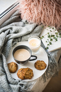 斯堪的纳维亚风格的早餐, 咖啡和饼干在舒适的窗台上与温暖的毯子和枕头