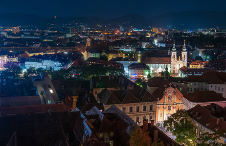 夜间格拉茨奥地利的全景。 三位一体教堂和Mariahilfkirche的明亮立面。 格拉茨历史中心被列入联合国教科文组织世界遗产