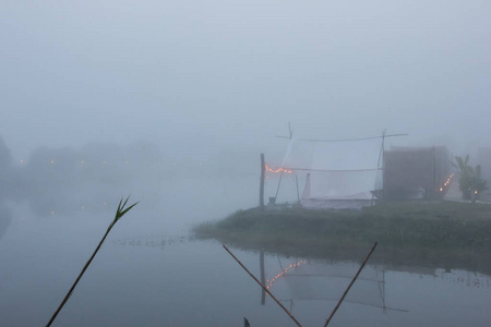 在雾蒙蒙的早晨，用山景把帐篷铺在河边。