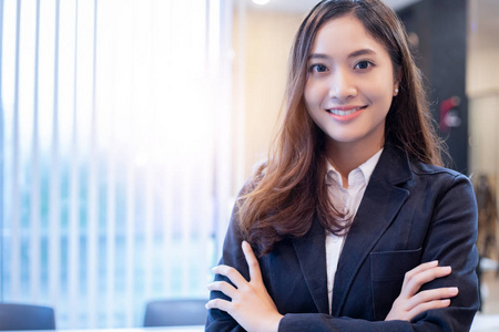 亚洲女商人站在明亮的办公室微笑的肖像。