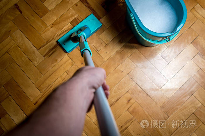 用湿雨刷拖把家务擦拭脏木地板打扫房子的人顶视图
