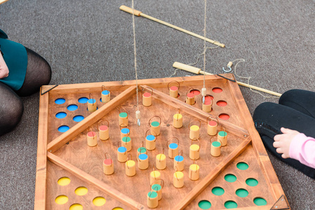 孩子们玩彩色形状的游戏。 在诱饵上抓住一个木头人物。 把数字放在地方。 儿童教育游戏