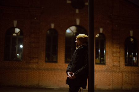 一个年轻人在晚间城市景观背景下的肖像。 傍晚城市灯火通明的帅哥