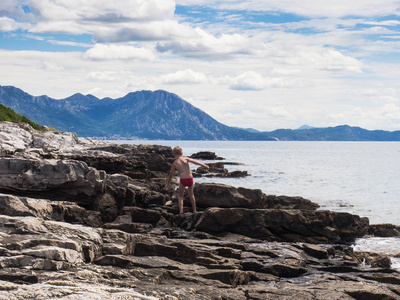 小男孩在克罗地亚瓦尔岛的石岸上玩耍和享受暑假