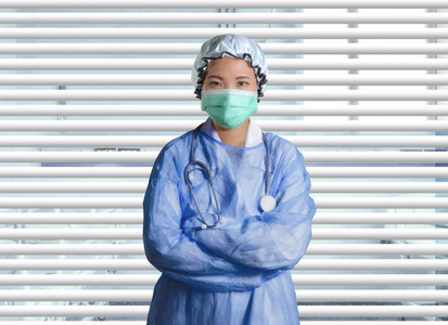 年轻自信成功的亚韩医学院女医生在医疗保健和企业医生的百叶窗病人室里洗衣服和戴面具