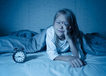 可爱的失眠小女孩躺在床上，看着悲伤和疲惫，有睡眠问题，晚上睡觉，或者凌晨醒来，失眠症，儿童焦虑睡眠障碍。