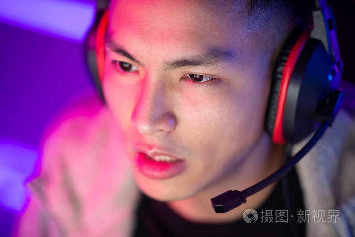 亚洲青年帅哥职业玩家现场直播和玩网络游戏的画像
