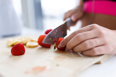 s hands while she cutting strawberries over wooden table in the 