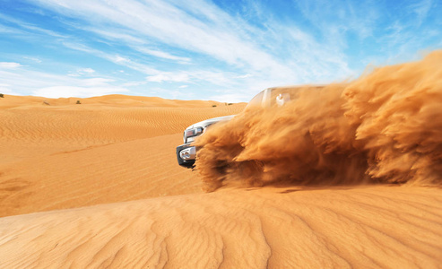 在沙漠中漂流越野车4x4。 爆炸沙粉进入空气的冻结运动。 动作和跳跃活动。