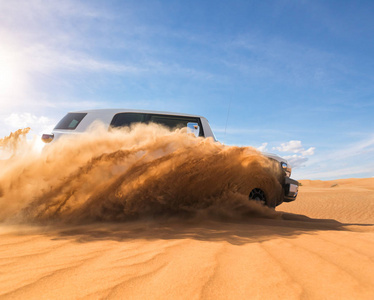 在沙漠中漂流越野车4x4。 爆炸沙粉进入空气的冻结运动。 动作和跳跃活动。