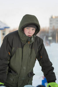 一名穿绿色夹克衫头罩的工人的肖像，从事安排一个冰城