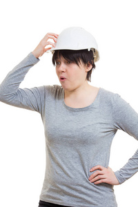 困惑的年轻女工程师戴着防护头盔，指着头，沉思的情绪，记得白色背景上孤立的东西。