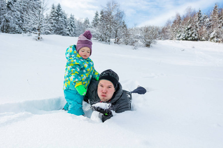 父亲和女儿在新鲜的雪中玩耍