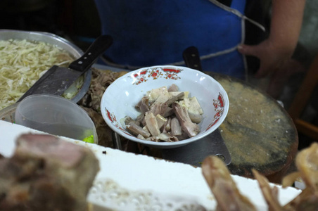 厨师烹饪面条与猪肉和猪肉内脏在当地餐厅泰国街头食品在萨肯纳洪泰国。